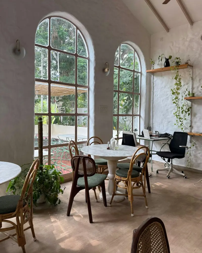 The café corner with cane chairs and arched windows